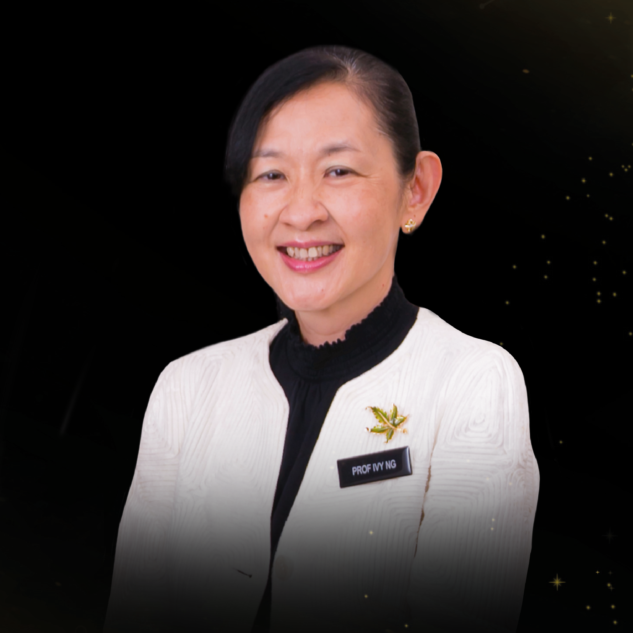 Smiling woman in a white blazer with a name badge reading Prof Ivy Ng against a dark background.